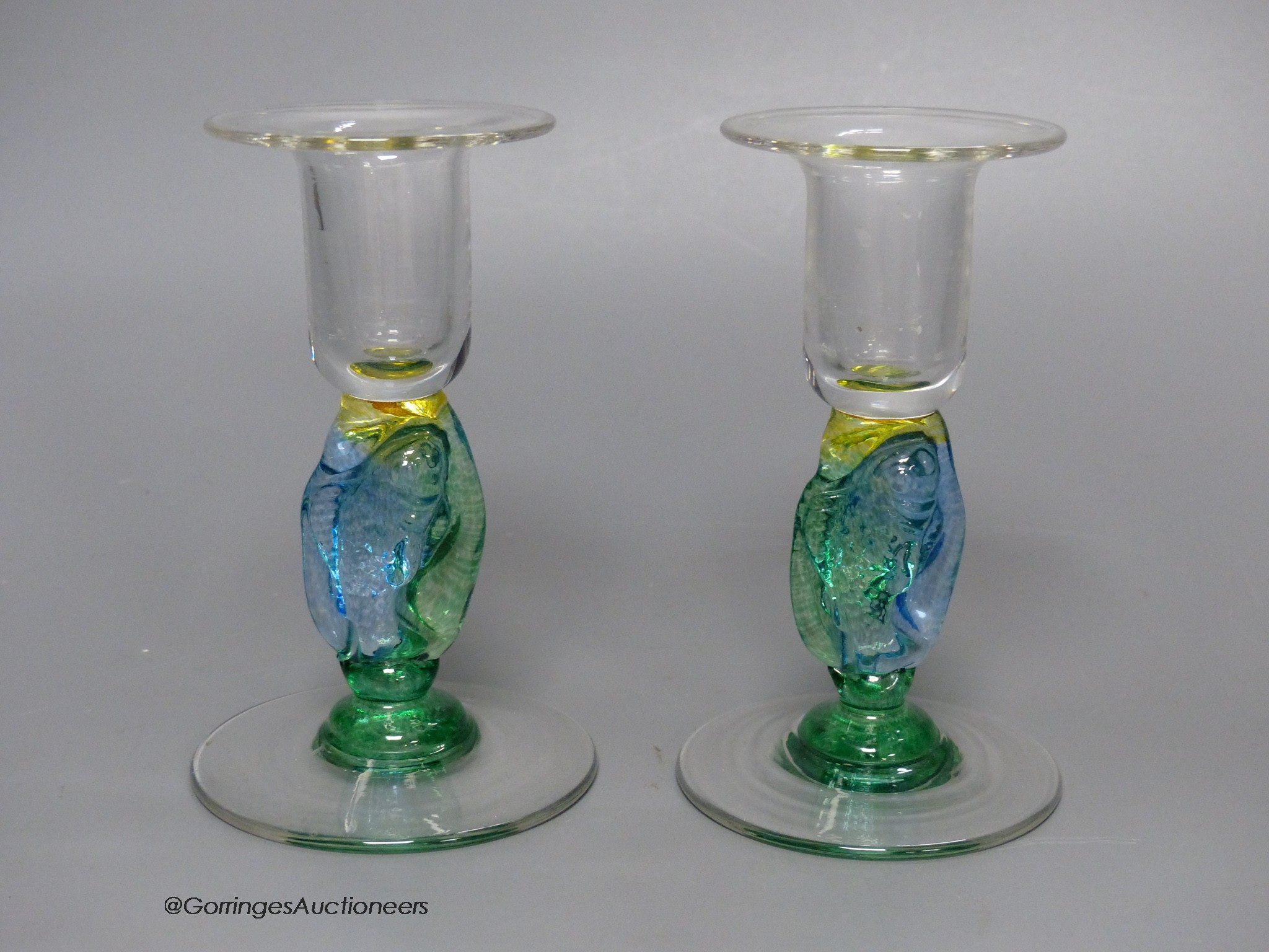 A pair of clear and coloured glass candlesticks by Helen Millard